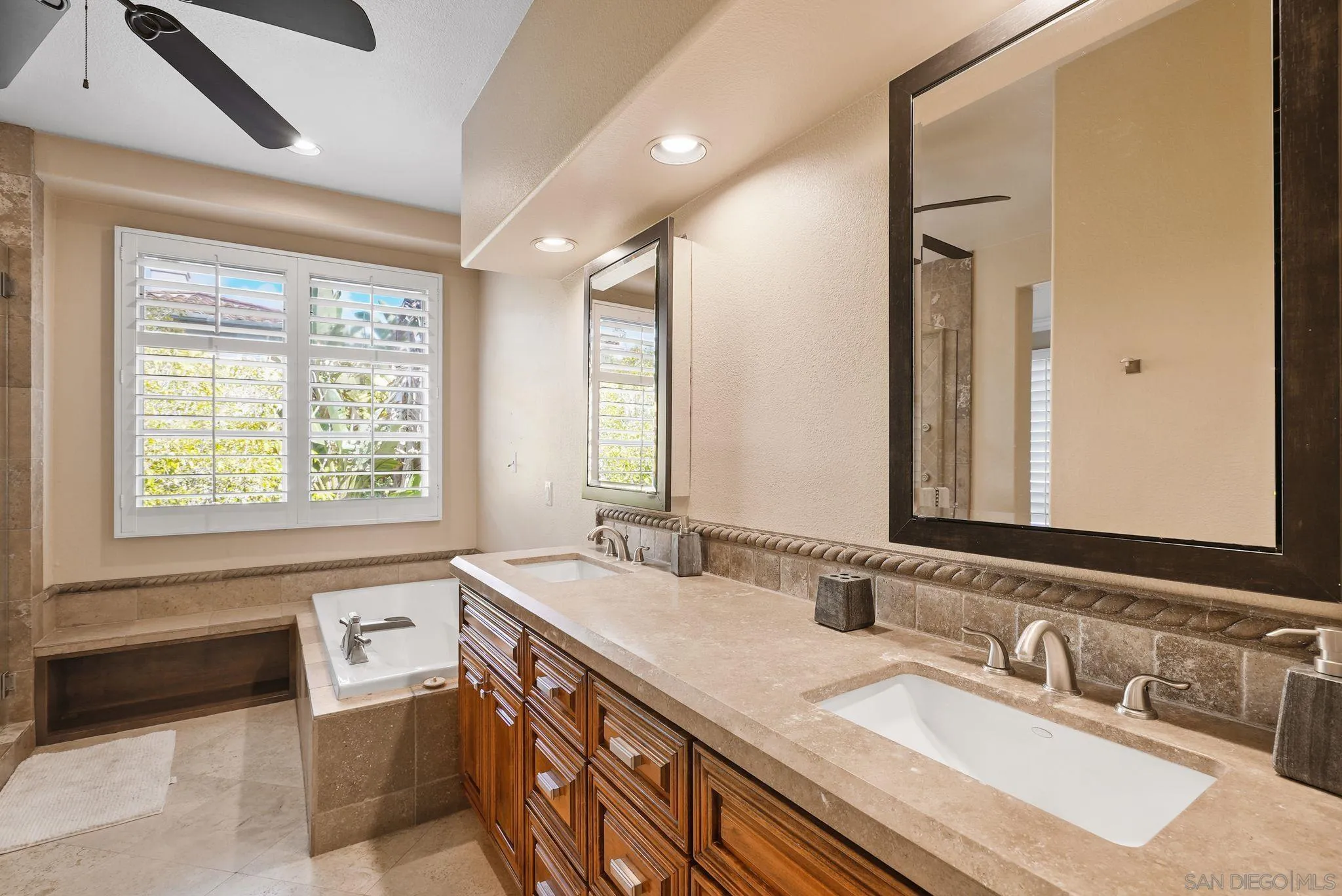 9683 Claiborne Square La Jolla, CA 92037 - Photo 39 of 67 a bathroom with a granite countertop sink mirror and a bathtub