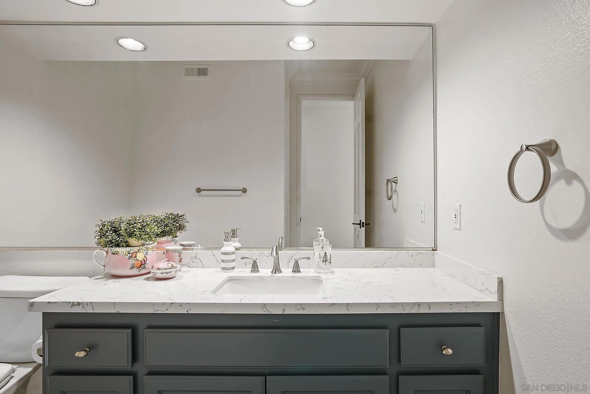 9683 Claiborne Square La Jolla, CA 92037 - Photo 50 of 67 a bathroom with a sink and a mirror
