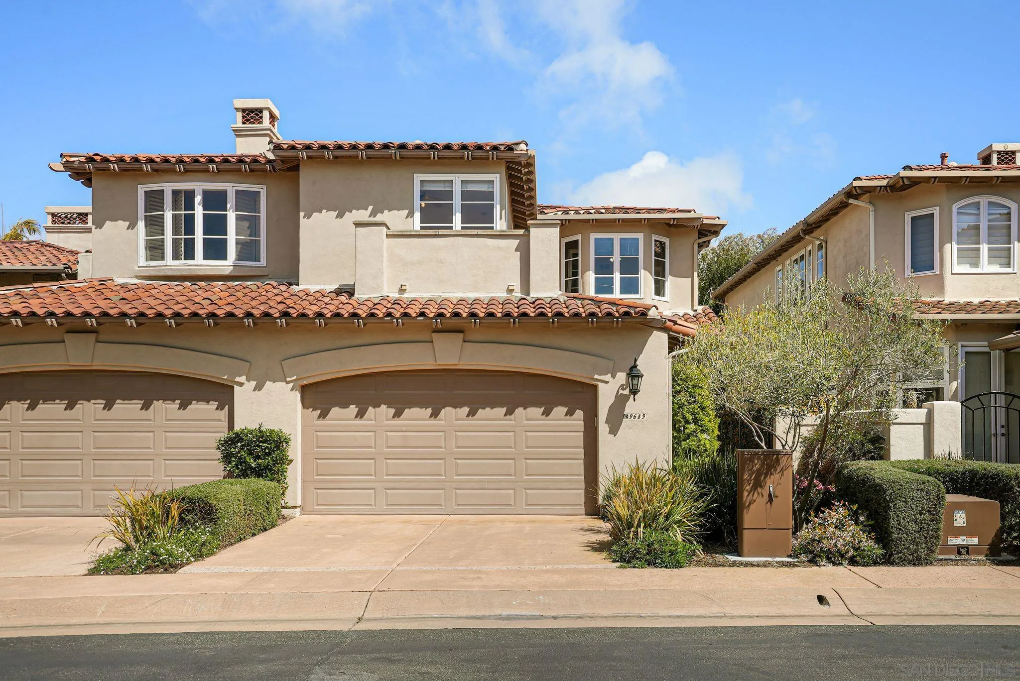 9683 Claiborne Square La Jolla, CA 92037 - Photo 66 of 67 a front view of a house with a yard and garage