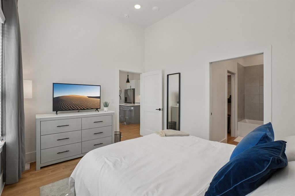 6418 Maple Avenue, Unit 307 Dallas, TX 75235 - Photo 10 of 16 a bedroom with a bed and a dresser
