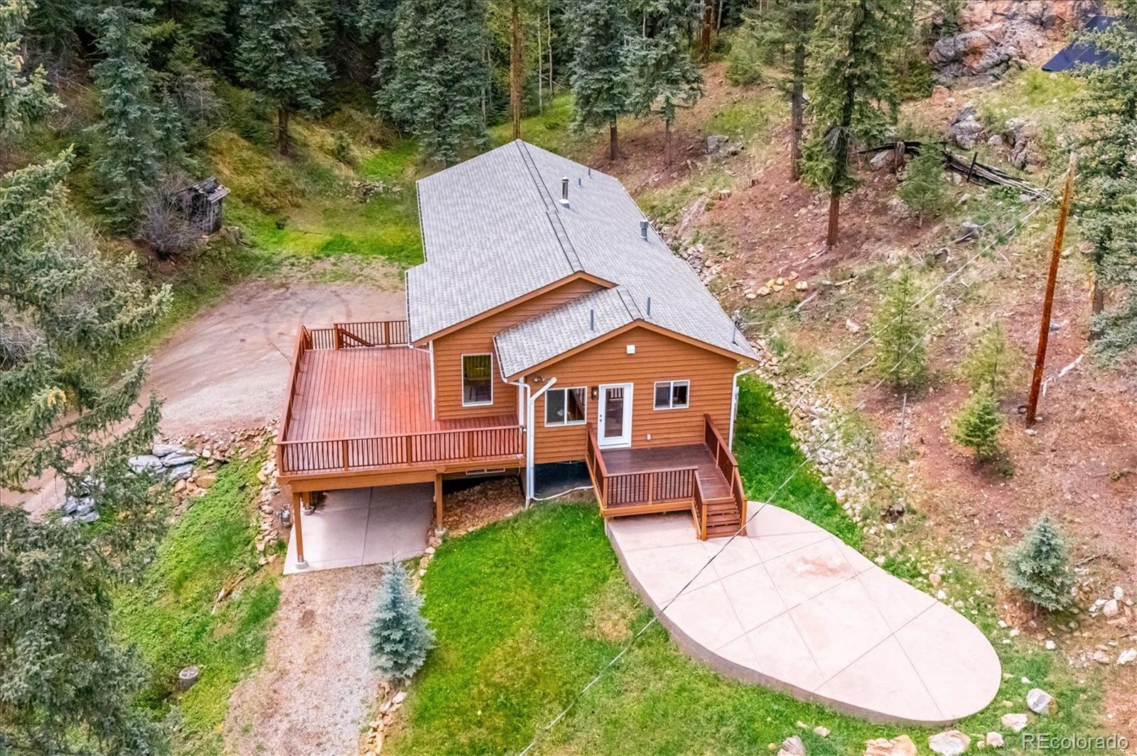 6747 South Brook Forest Road Evergreen, CO 80439 - Photo 42 of 49 an aerial view of a house with a yard table and chairs