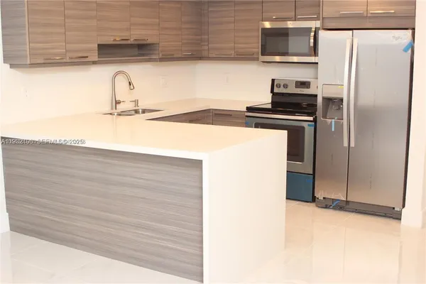 a kitchen with a refrigerator and a sink