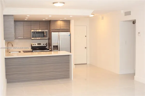 a kitchen with kitchen island a sink stainless steel appliances and cabinets