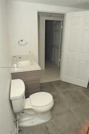 a white toilet sitting next to a bathroom sink