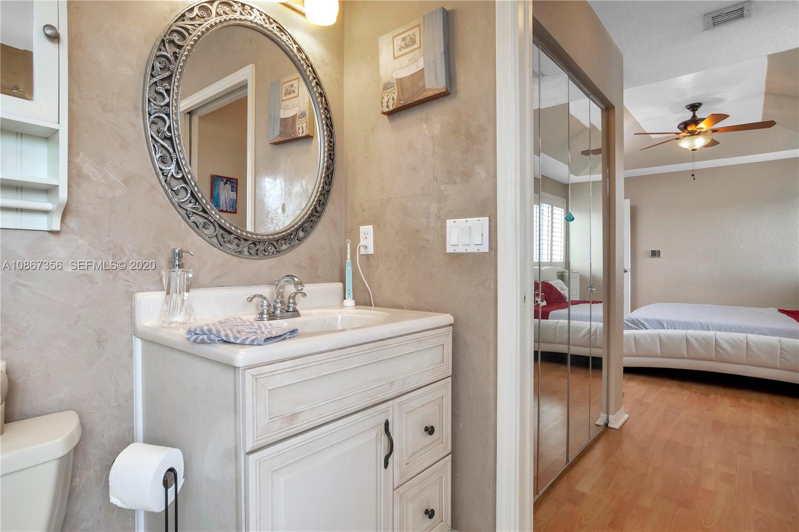 11360 Rockinghorse Road Cooper City, FL 33026 - Photo 25 of 31 a en suite bathroom with a toilet sink and mirror