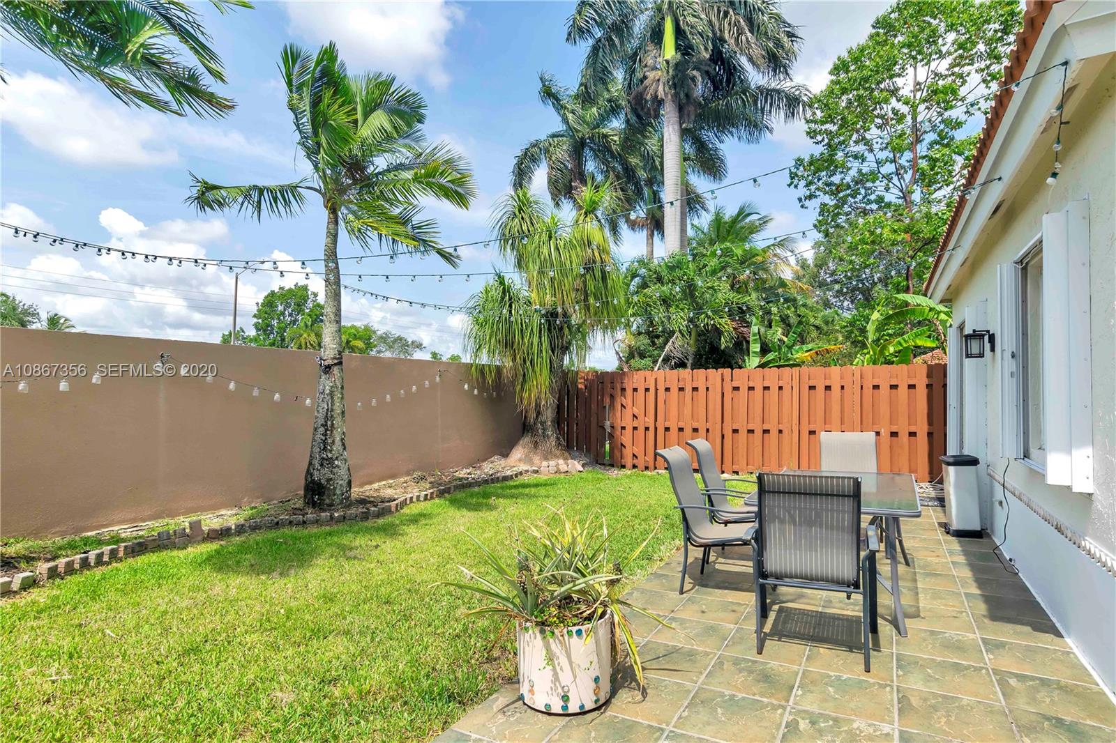 11360 Rockinghorse Road Cooper City, FL 33026 - Photo 29 of 31 a wooden bench sitting in backside of a house with potted plants