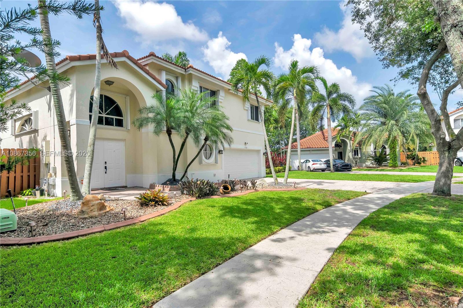 11360 Rockinghorse Road Cooper City, FL 33026 - Photo 3 of 31 a view of a white house with a big yard and large trees