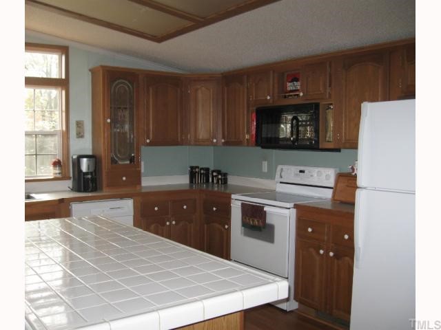 533 Powhatan Road Clayton, NC 27527 - Photo 3 of 12 Kitchen has large island, smoothtop range, microwave, dishwasher, and refrigerator.