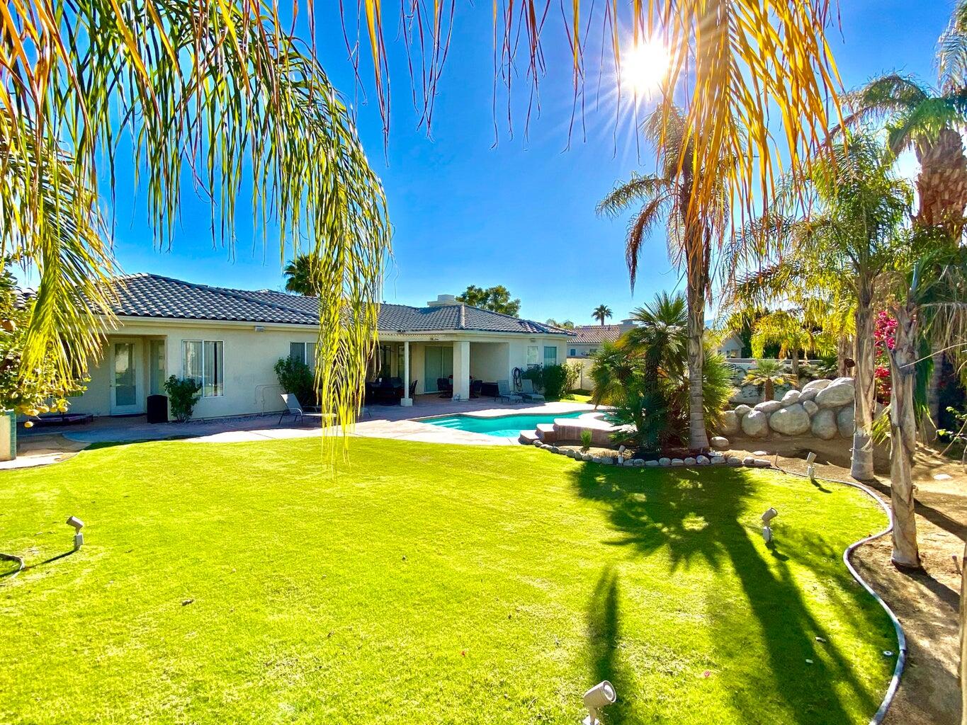 5 Victoria Falls Drive Rancho Mirage, CA 92270 - Photo 1 of 26 a view of swimming pool with lawn chairs under an umbrella