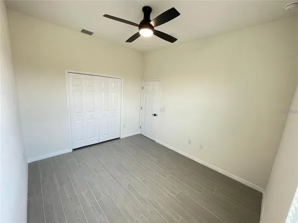 an empty room with a ceiling fan and carpet