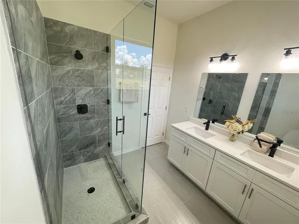 a bathroom with a shower sink and mirror