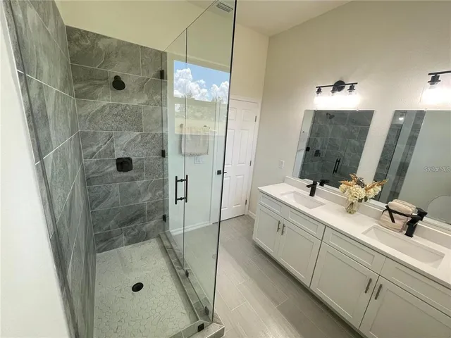 a bathroom with a shower sink and mirror