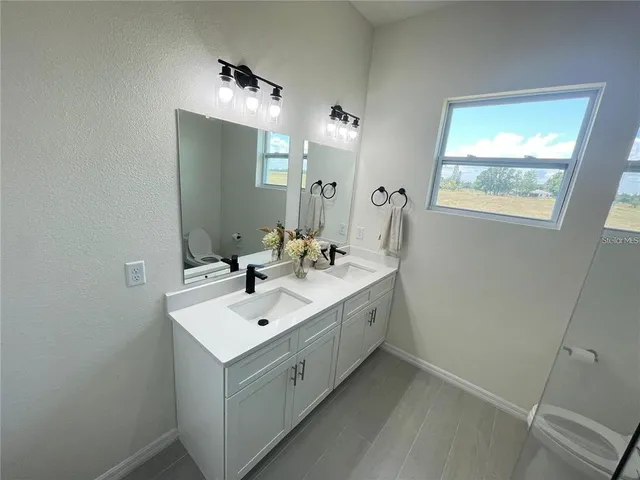 a bathroom with a double vanity sink and mirror