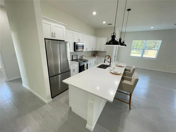 a kitchen with stainless steel appliances a refrigerator a sink dishwasher and a stove