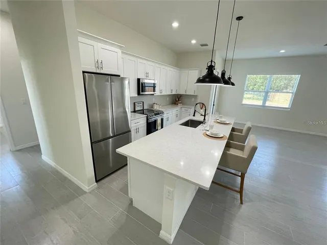 a kitchen with stainless steel appliances a refrigerator a sink dishwasher and a stove