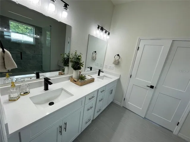 a bathroom with double vanity sink and mirror