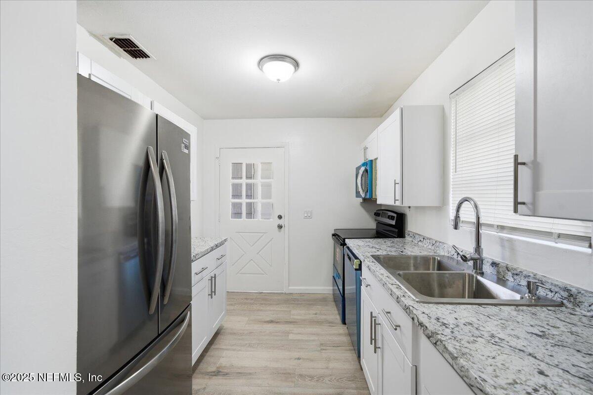 2142 Fouraker Road Jacksonville, FL 32210 - Photo 15 of 29 a kitchen that has a sink a refrigerator and a sink