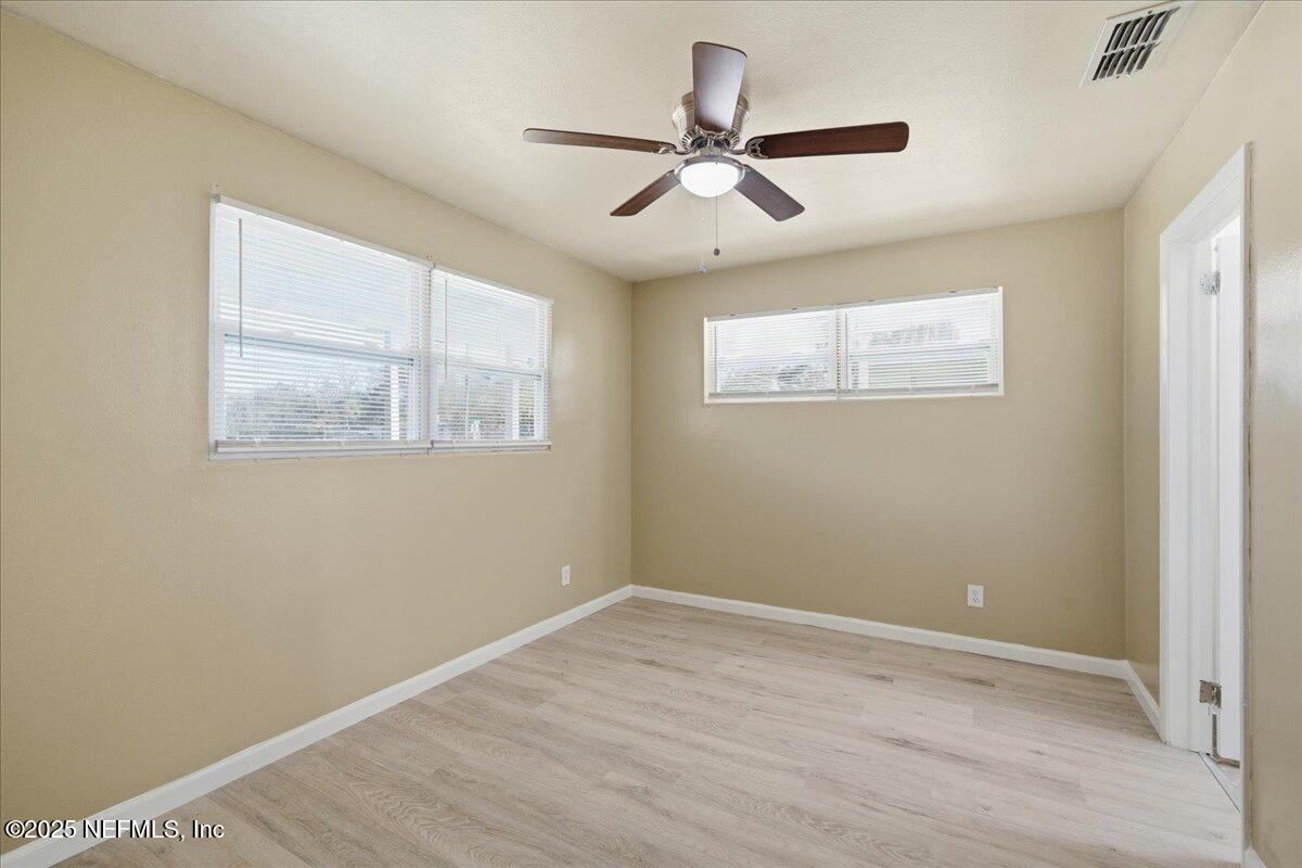 2142 Fouraker Road Jacksonville, FL 32210 - Photo 18 of 29 a view of an empty room with wooden floor and a window