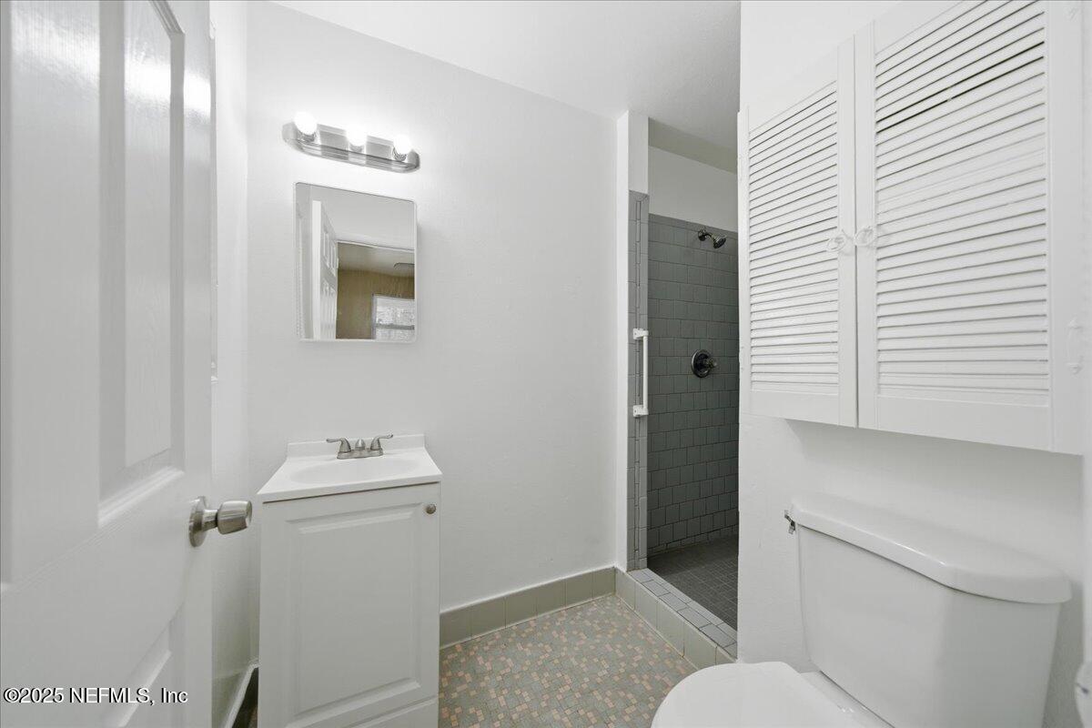 2142 Fouraker Road Jacksonville, FL 32210 - Photo 20 of 29 a bathroom with a toilet sink and mirror