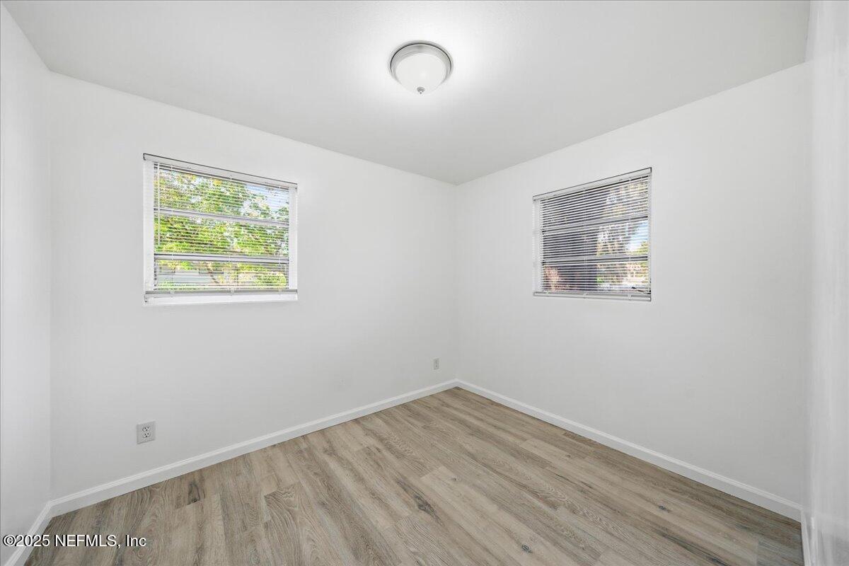 2142 Fouraker Road Jacksonville, FL 32210 - Photo 25 of 29 an empty room with wooden floor and windows