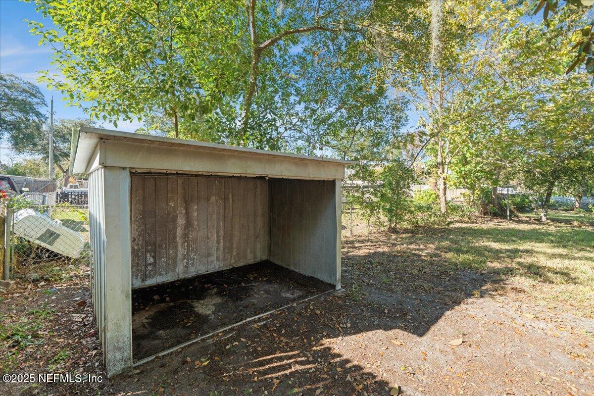2142 Fouraker Road Jacksonville, FL 32210 - Photo 28 of 29 a backyard of a house with large trees and wooden fence
