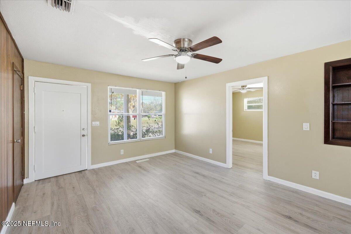 2142 Fouraker Road Jacksonville, FL 32210 - Photo 8 of 29 a view of an empty room with a window and wooden floor