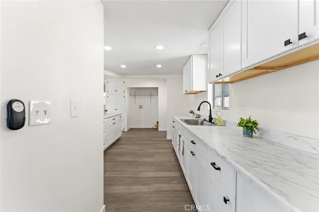 a large kitchen with granite countertop a sink and a stove