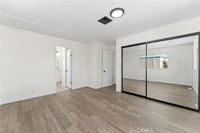 an empty room with wooden floor and sliding door