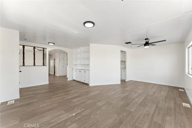 a view of a livingroom with wooden floor and a ceiling fan