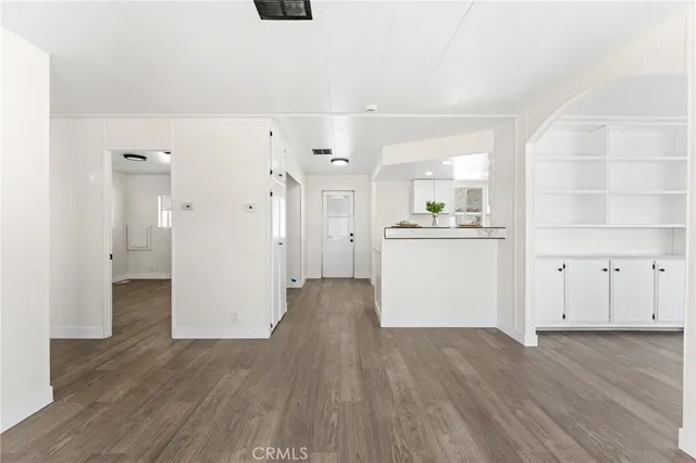 a view of a kitchen with refrigerator and wooden floor