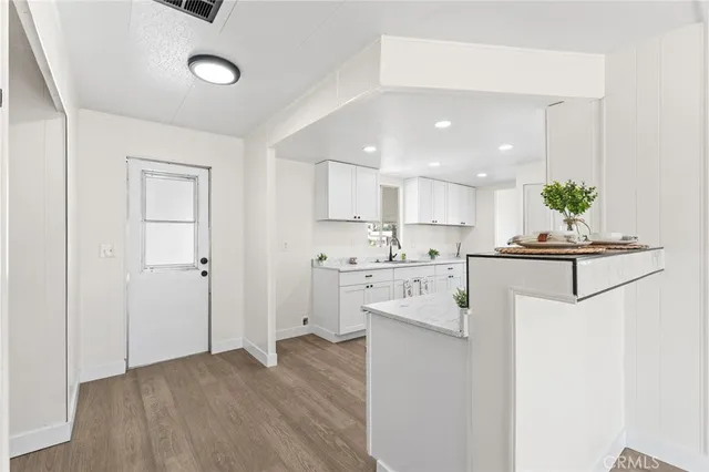 a kitchen view with white cabinets and stainless steel appliances