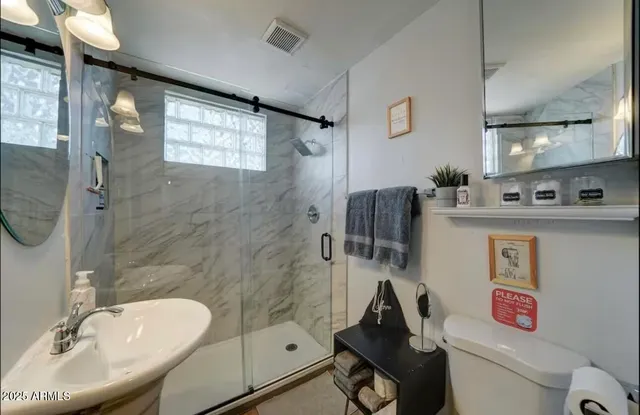 a bathroom with a sink toilet and shower