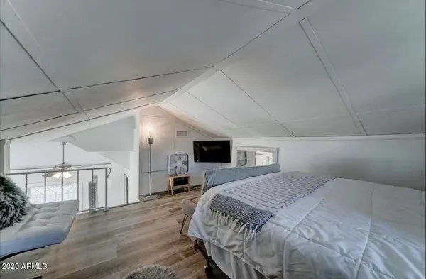 a bedroom with a bed and a flat screen tv