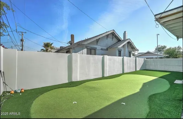 a view of backyard with large trees and a wooden fence