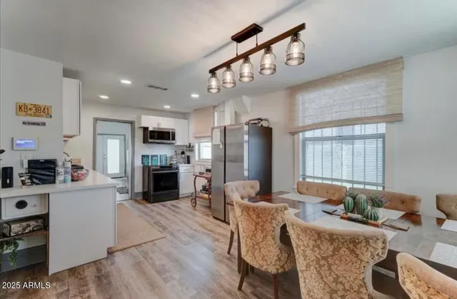 a living room with furniture a fireplace and a open kitchen view