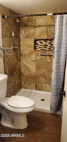 a bathroom with a toilet and a shower