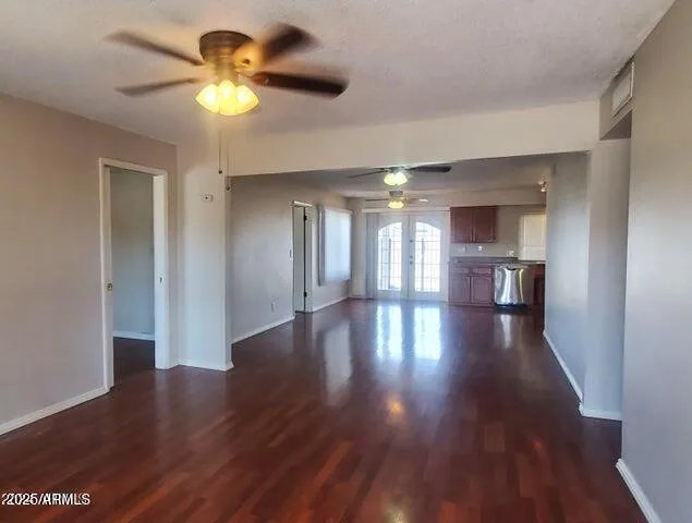 a view of an empty room with a window and wooden floor
