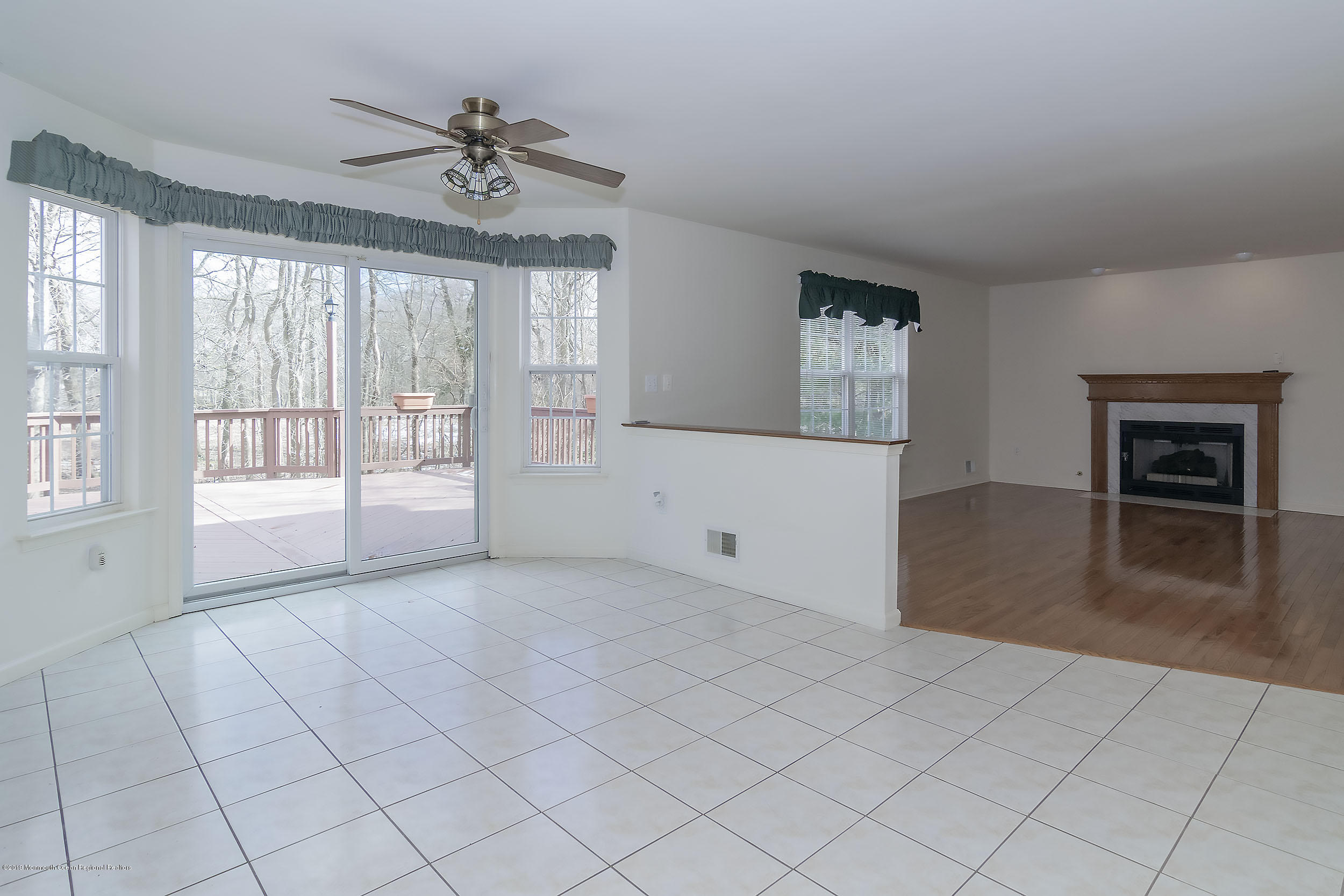 403 Meadowood Road Jackson, NJ 08527 - Photo 15 of 46 an empty room with chandelier fan and windows