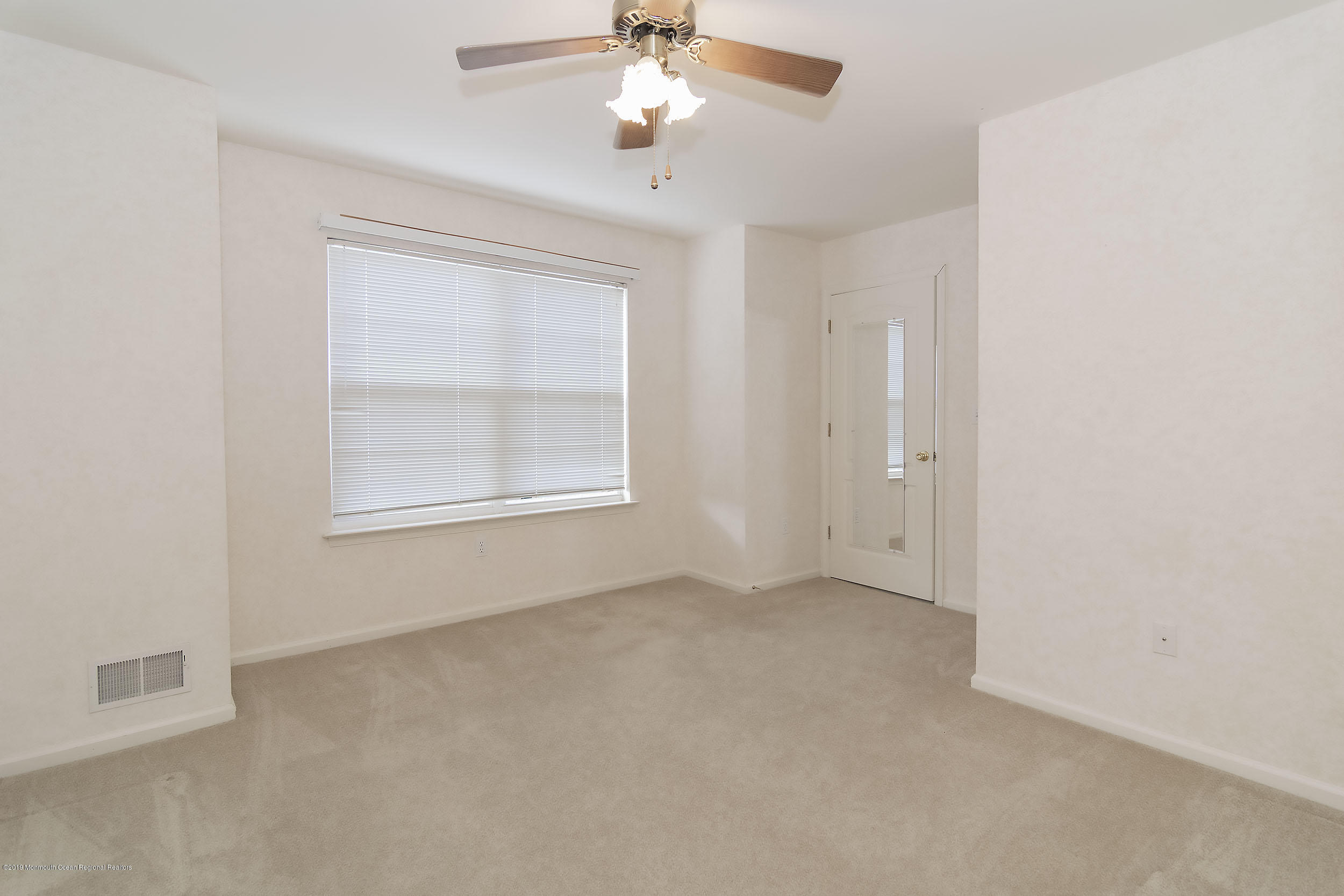 403 Meadowood Road Jackson, NJ 08527 - Photo 21 of 46 an empty room with a window and a ceiling fan