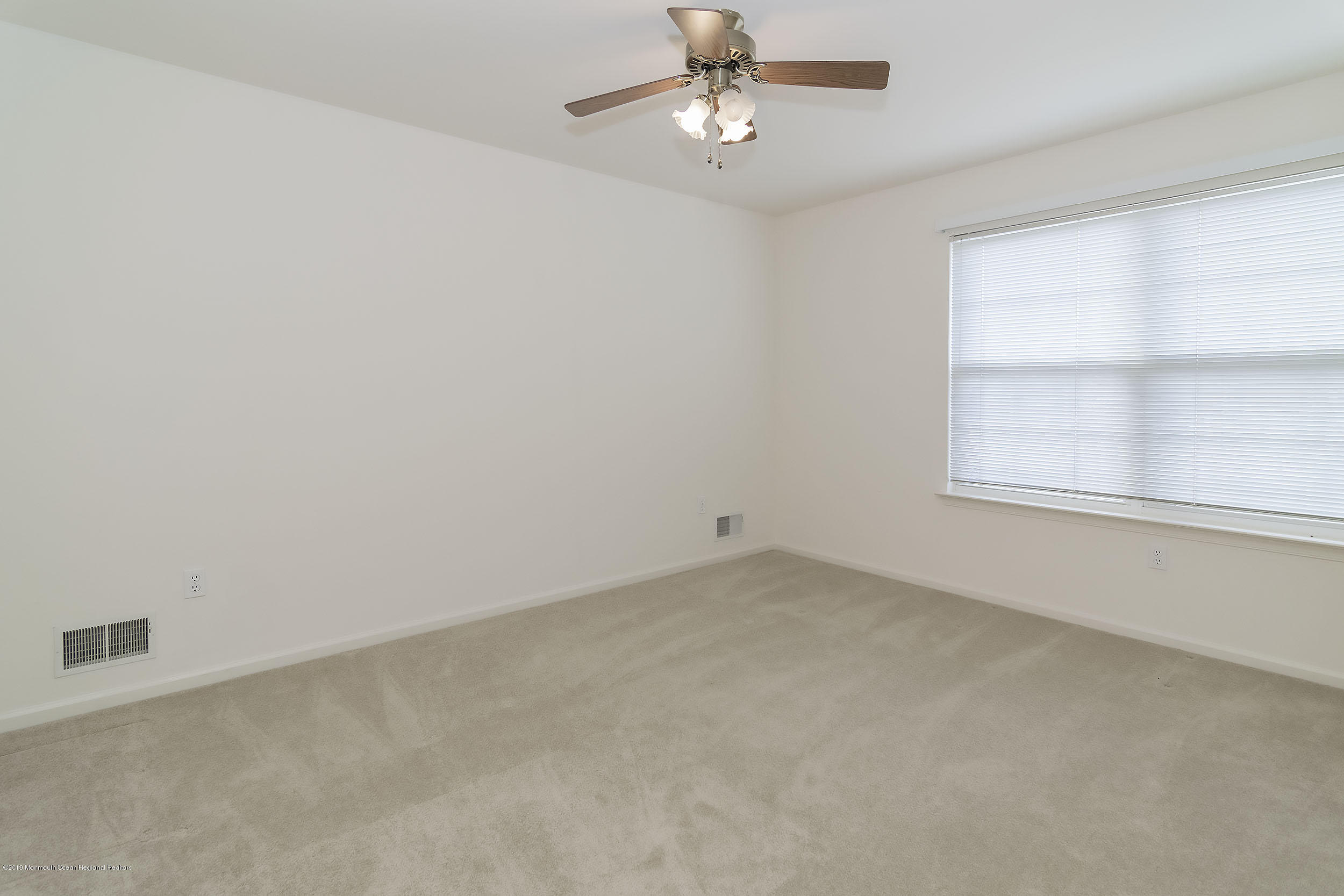 403 Meadowood Road Jackson, NJ 08527 - Photo 22 of 46 an empty room with a window and ceiling fan