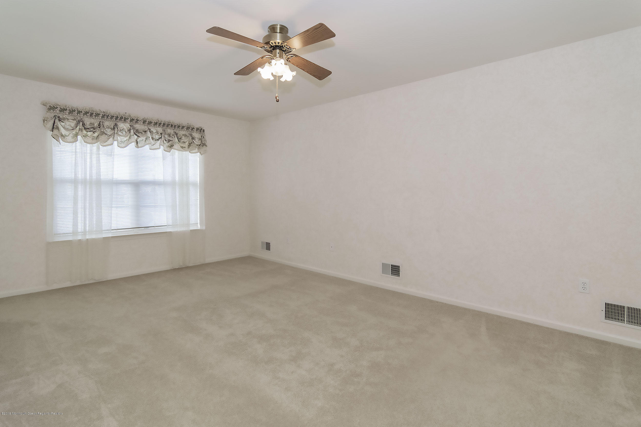 403 Meadowood Road Jackson, NJ 08527 - Photo 26 of 46 an empty room with a window and a fan