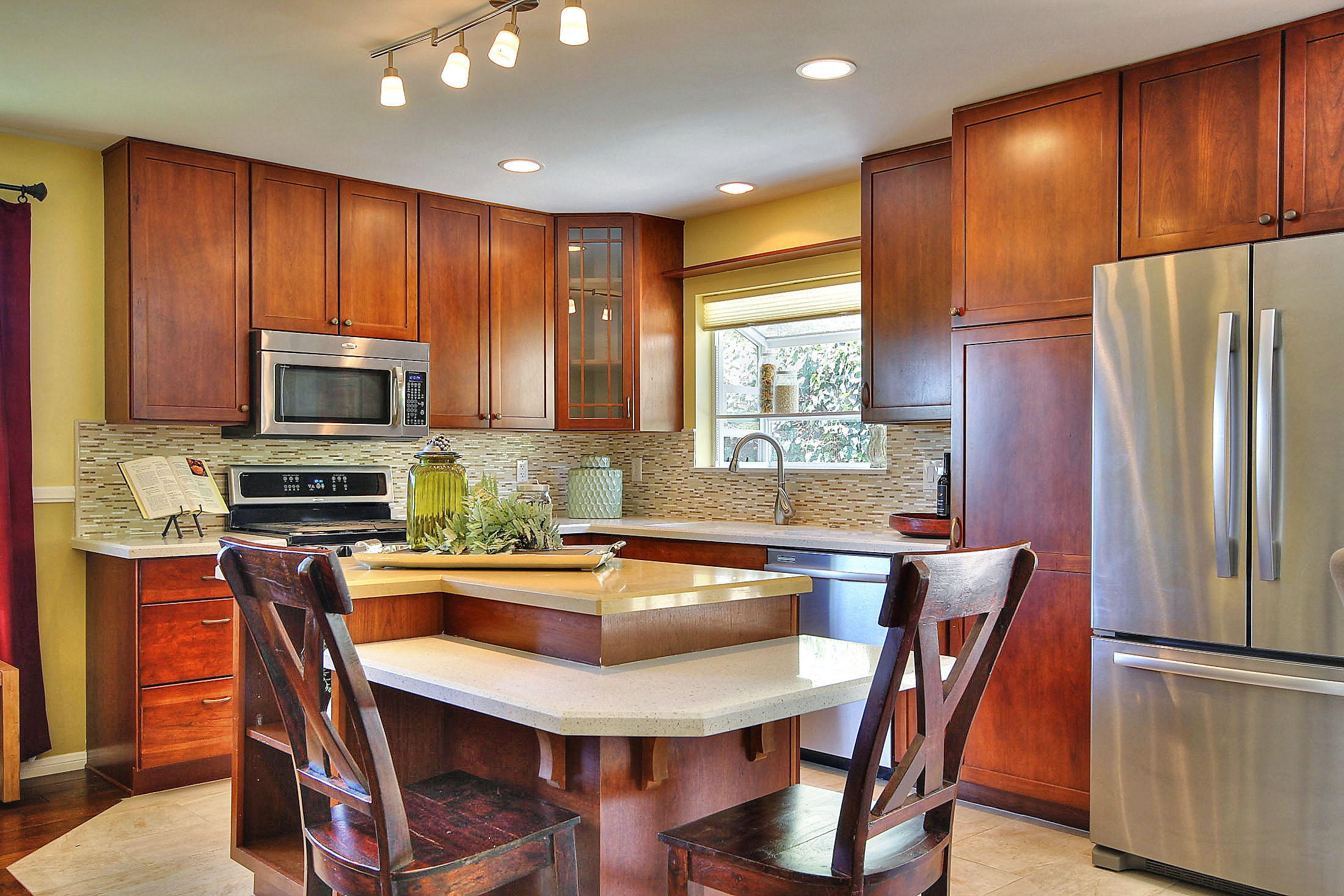 515 Fellowship Road Santa Barbara, CA 93109 - Photo 8 of 25 a kitchen with stainless steel appliances granite countertop a refrigerator a stove a sink a dining table and chairs with wooden floor