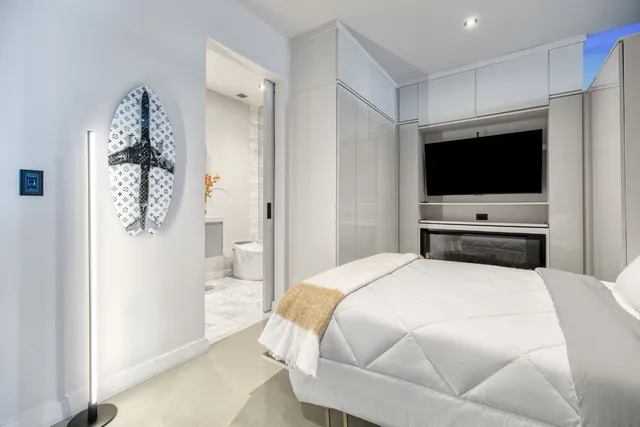 a bedroom with a bed window and a flat screen tv