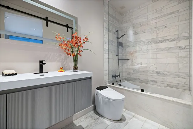 a bathroom with a sink a toilet and shower