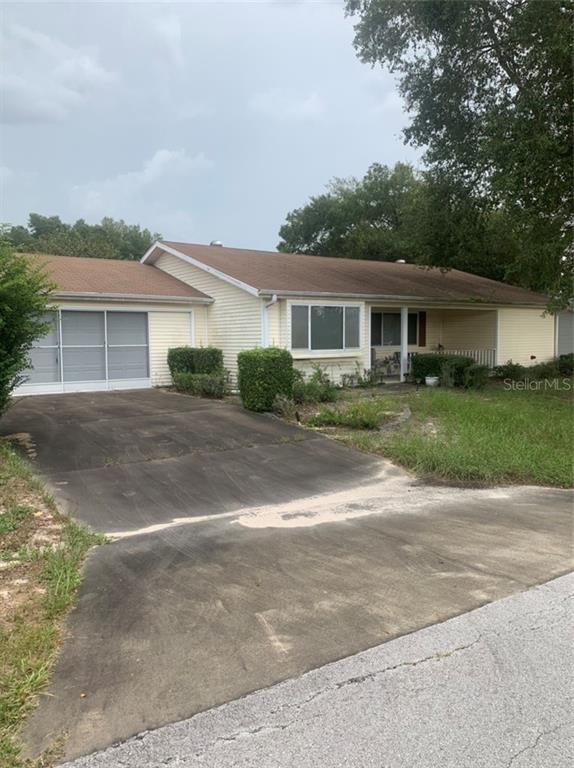 8825 Southwest 116th Place Road Ocala, FL 34481 - Photo 1 of 1 a front view of house with yard and trees around