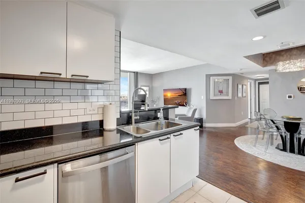 a kitchen with stainless steel appliances granite countertop a sink a stove and cabinets