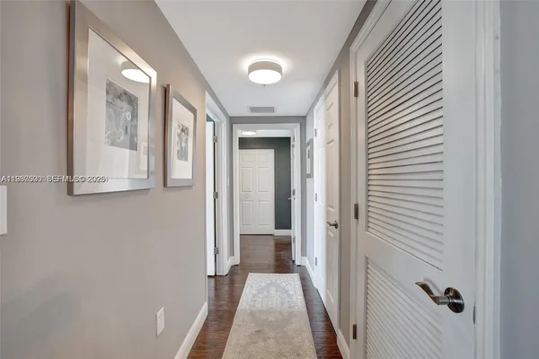 a view of a hallway with wooden floor and staircase