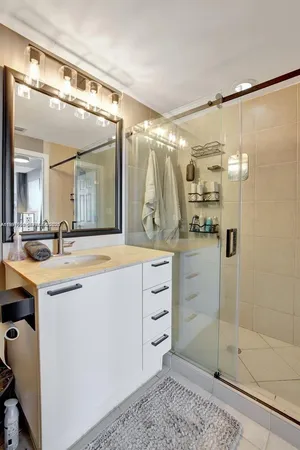 a spacious bathroom with a shower sink and mirror