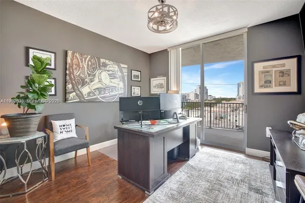 a view of a workspace with furniture and a window