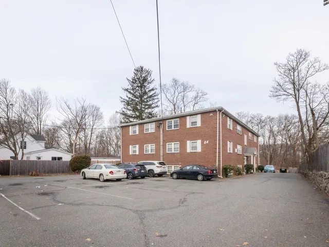 a front view of a building with a road and a building
